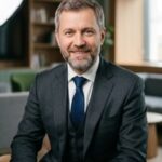 Профессиональный портрет уверенного российского бизнесмена на размытом фоне для сайта разработки финансовых приложений